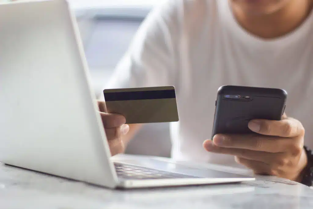 person holding credit card and phone