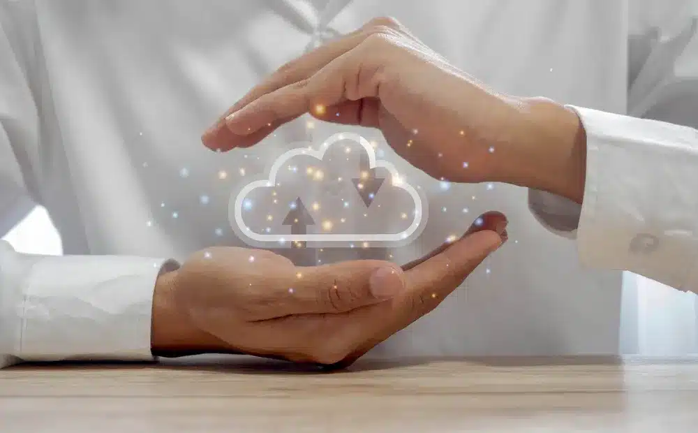 1. A man holds a cloud icon in his hands, symbolizing technology and innovation in cloud computing.