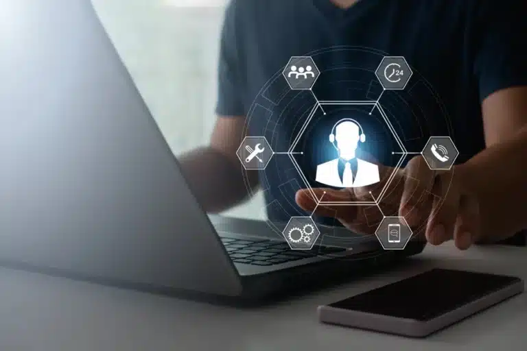 Man using a laptop with a call center icon displayed on the screen, representing AI call center agents in action.