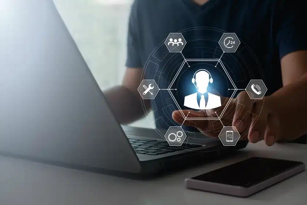 Man using a laptop with a call center icon displayed on the screen, representing AI call center agents in action.