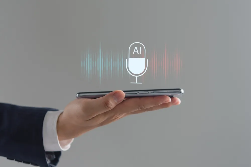 Man holding a smartphone with a microphone, illustrating the concept of voice assistant technology.