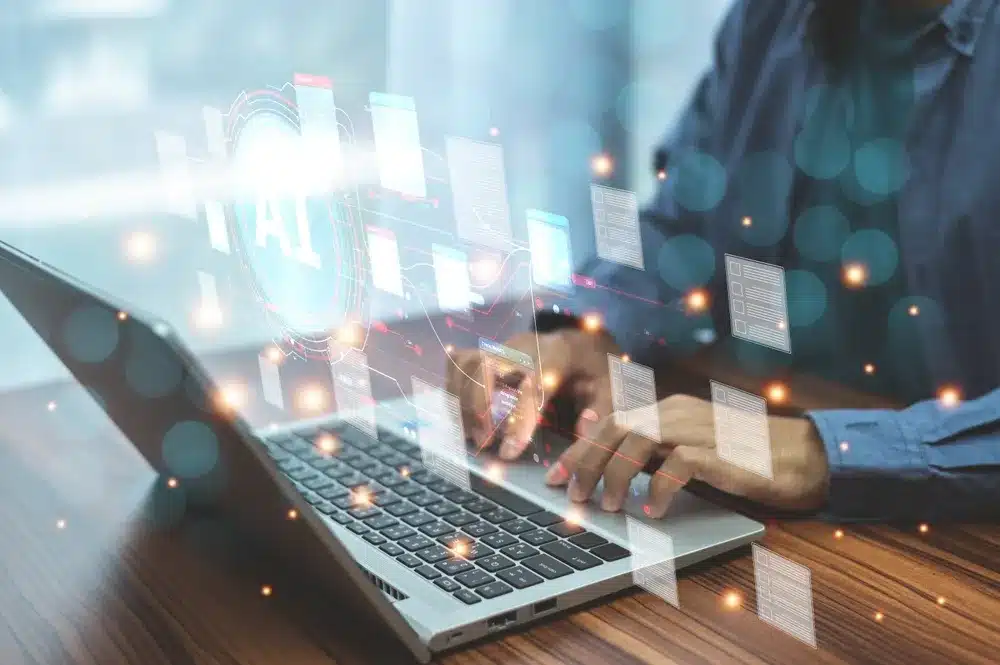 A man focused on a laptop, interacting with a digital interface displayed on the screen.