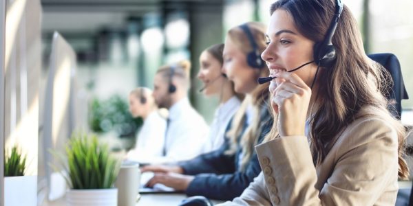 Female,Customer,Support,Operator,With,Headset,And,Smiling,,With,Collegues